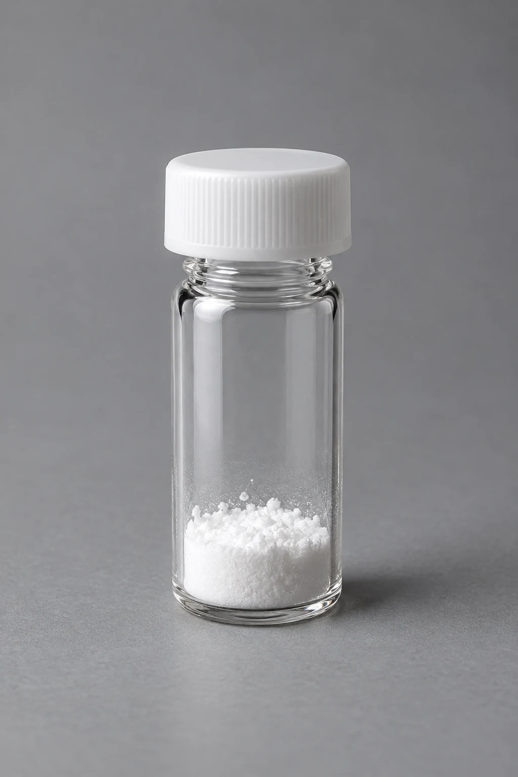 A sealed vial of freeze-dried powder on a glass surface